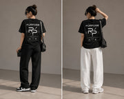 Rise With Purpose black Sorona t-shirt with graphic print on back, worn by a woman with loose-fitting pants.